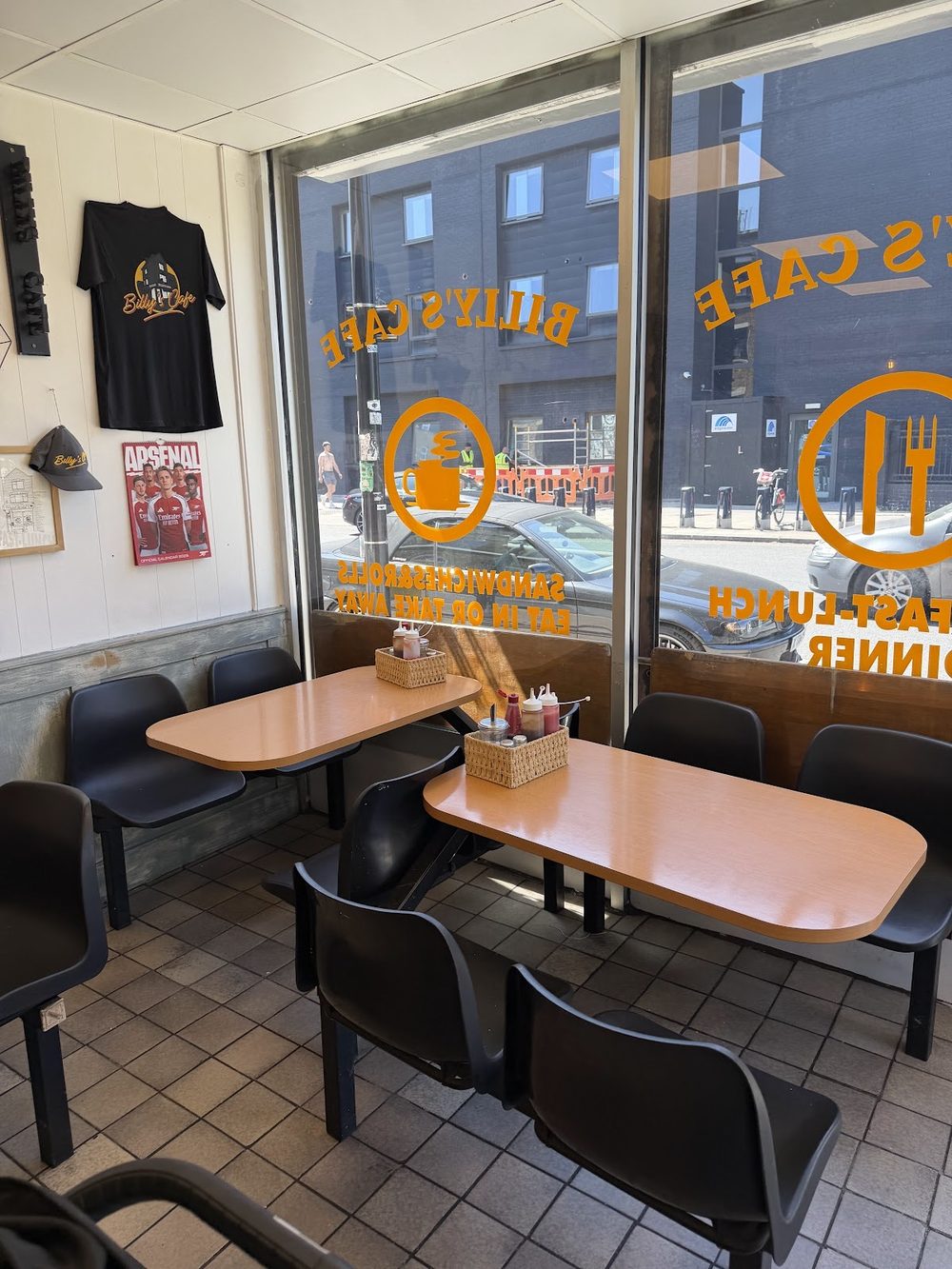 Tables and black chairs in the window seating area of Billy's Cafe.