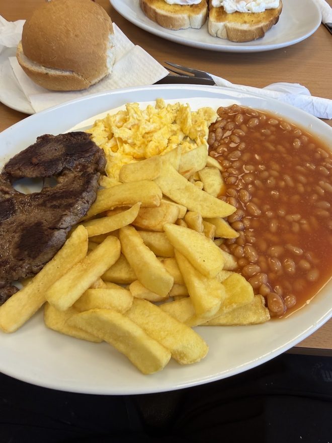 Steak, chips, scrambled egg and beans.